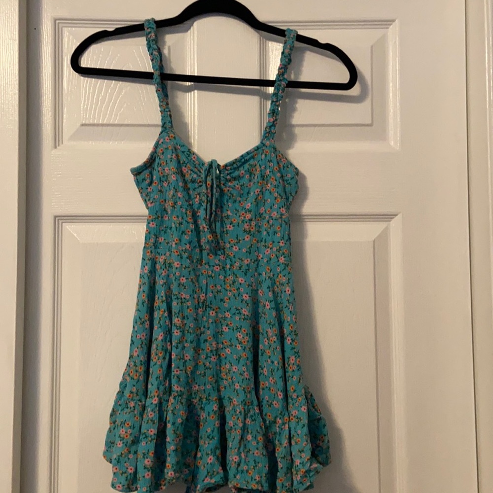 Teal romper with floral pattern.